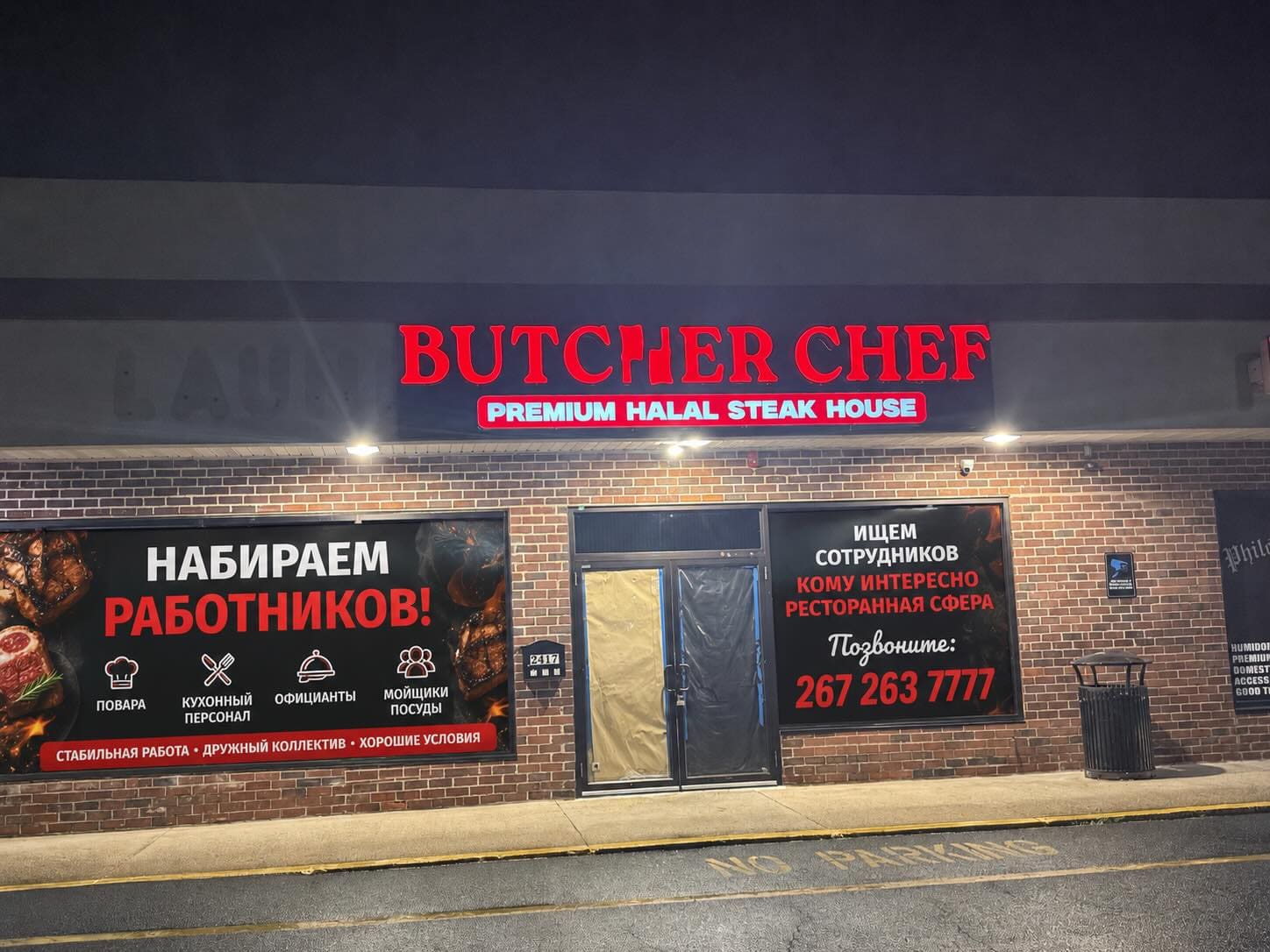 The red neon Butcher Chef Premium Halal Steak House sign glowing at night.